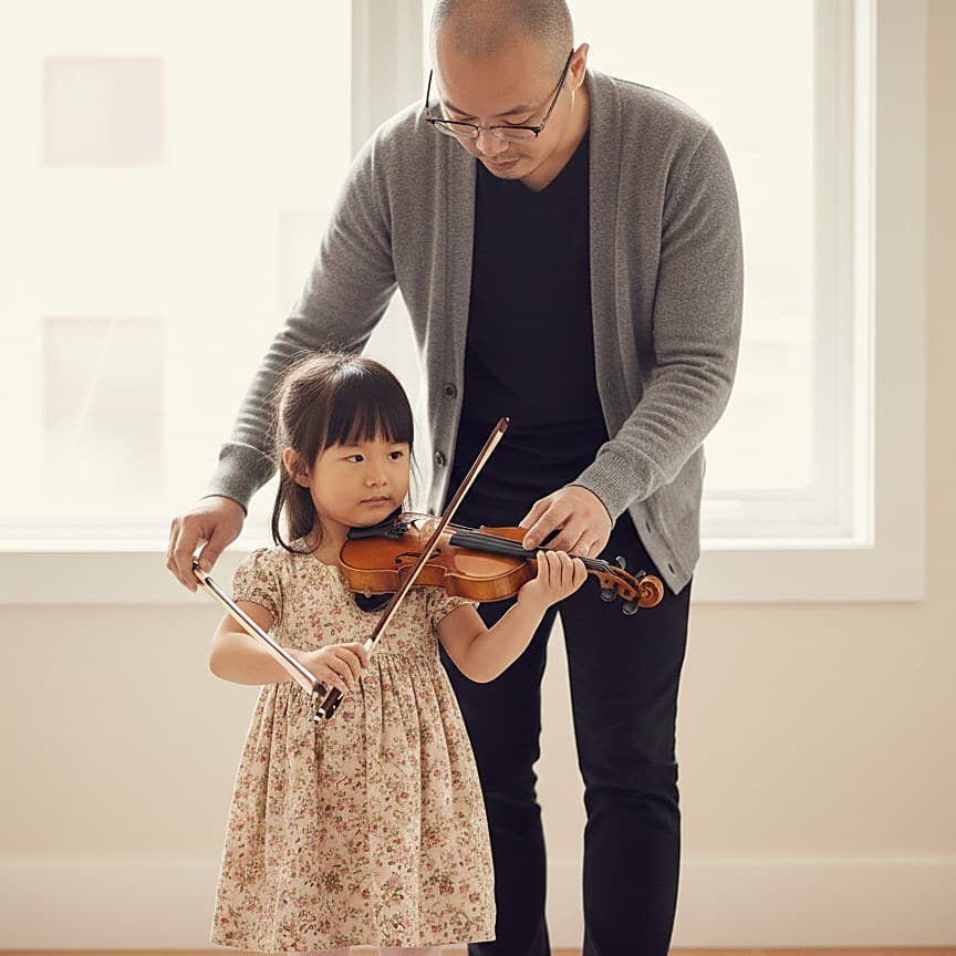 Baek Kim helping a young student with bow hold during a violin lesson